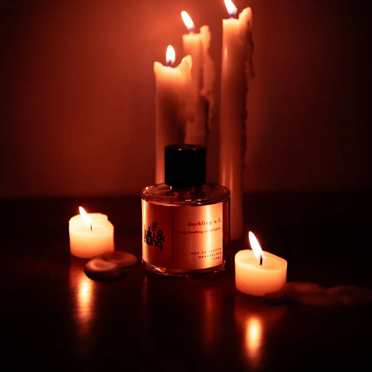 Darkling A.F. among lit candles in a dark red room